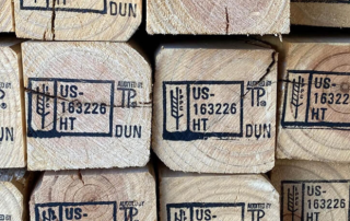 Close-up image of dunnage lumber with heat treatment and dunnage markers stamped in black.